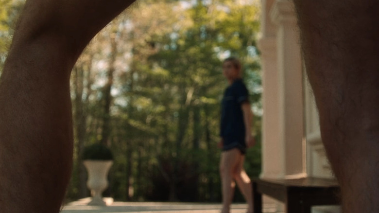 Maddie Hasson's Sage is seen through a pair of legs in Bone Lake