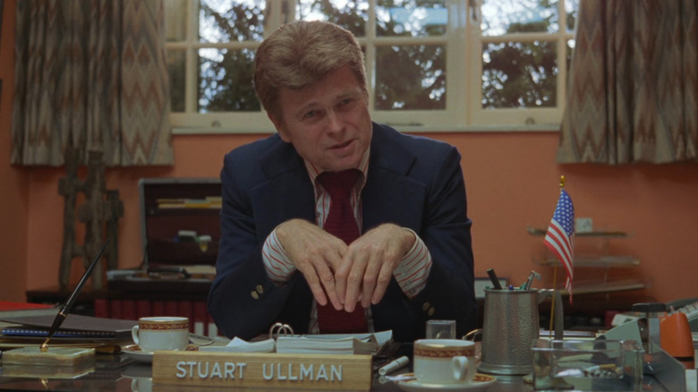 Stuart Ullman sitting at his desk in The Shining