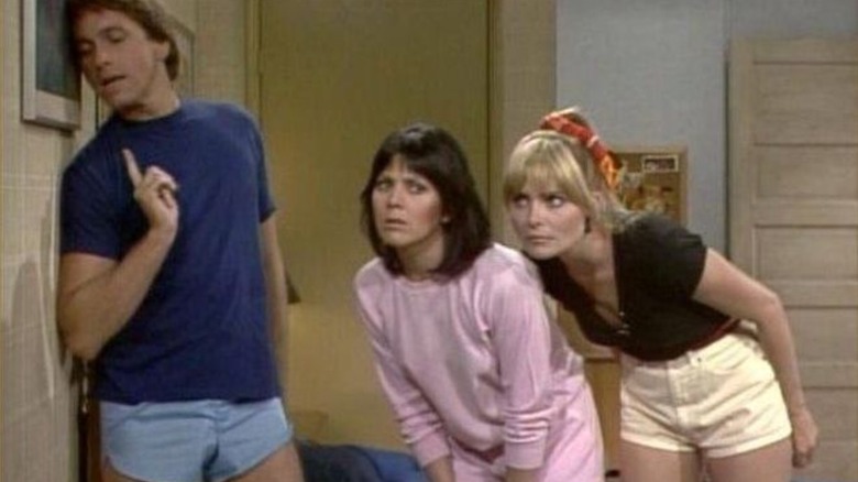 Jack, Janet, and Terri listening to something through the wall in Three's Company
