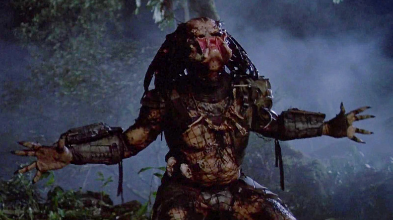 The Predator reaching its arms out and roaring in Predator