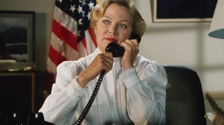 Louise Fletcher as Eileene Draygon on the phone in front of the American flag in Grizzly II: Revenge