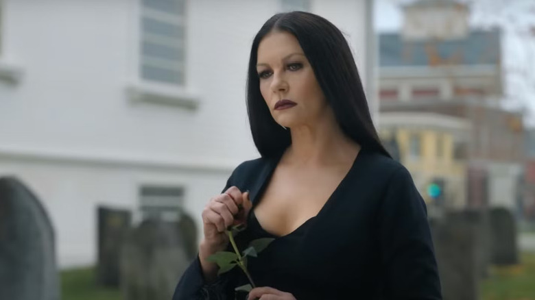 Morticia holding a flower on Wednesday
