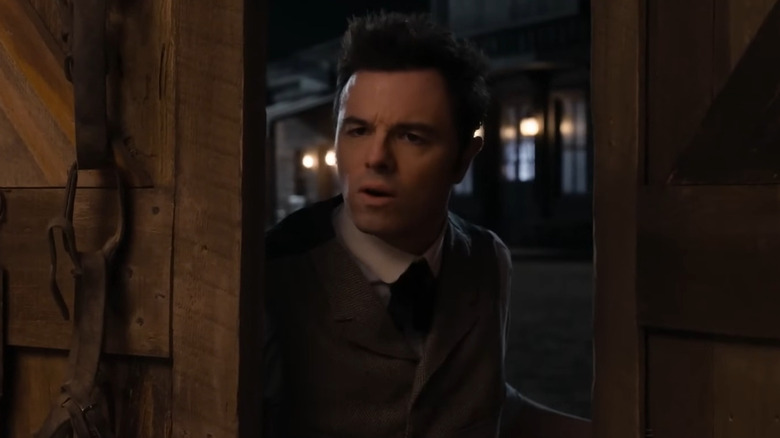 Albert peeking into a barn door in A Million Ways to Die in the West
