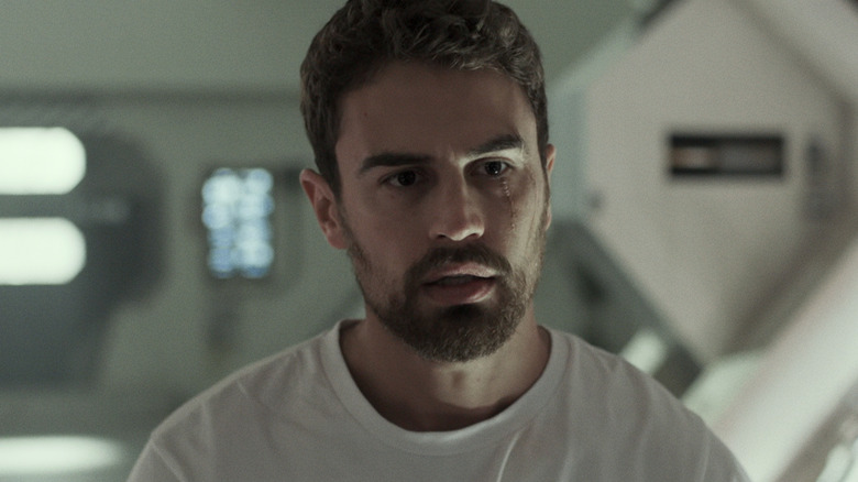 Theo James's George Almore stands looking worried in his lab in Archive