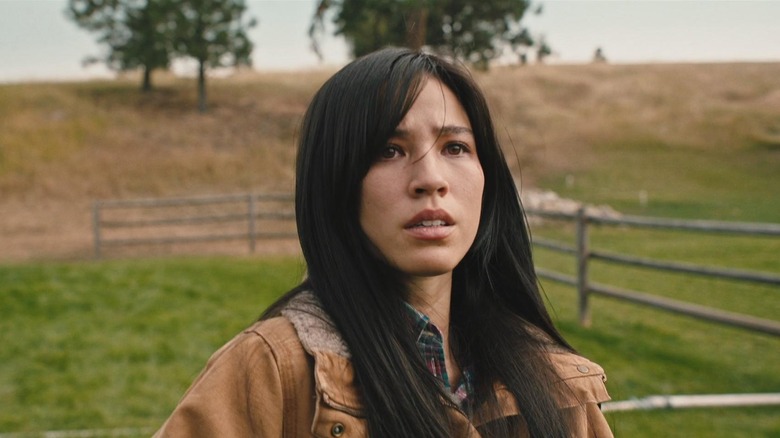 Kelsey Asbille as Monica Dutton standing in a field in Yellowstone