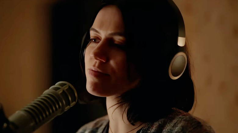 Nina Kiri as Evy wearing headphones next to a microphone in Undertone