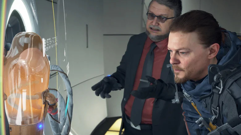 Sam and Guillermo del Toro look at a baby in a vat in Death Stranding