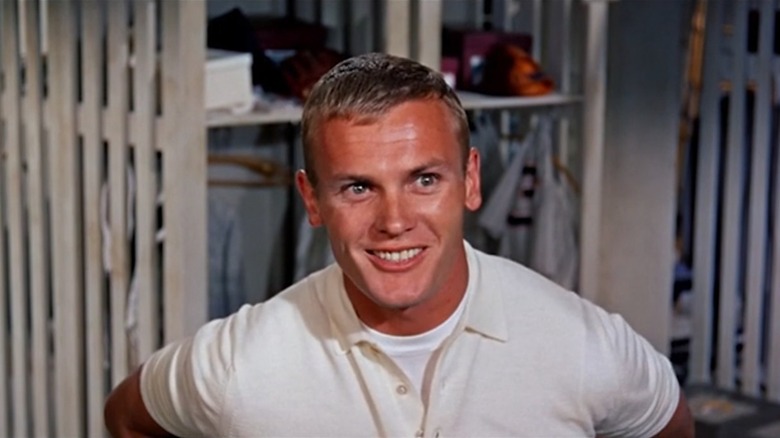 Joe Hardy (Tab Hunter) in the baseball team's locker room, smiling, in Damn Yankees