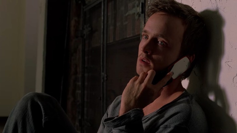 Jesse Pinkman (Aaron Paul) leans against a wall and talks on his flip phone, from Breaking Bad Season 3