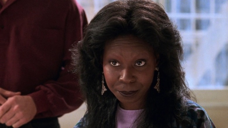 Oda Mae Brown (Whoopi Goldberg) from Ghost sitting at a table, warning Molly that she's in danger