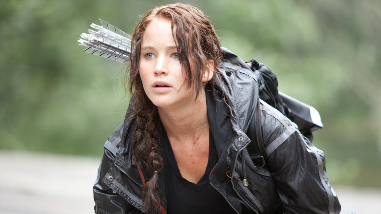 Jennifer Lawrence as Katniss Everdeen crouching in The Hunger Games