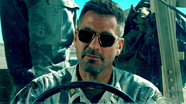 George Clooney as Major Archie Gates, sitting behind the wheel of a car with shades on in Three Kings.