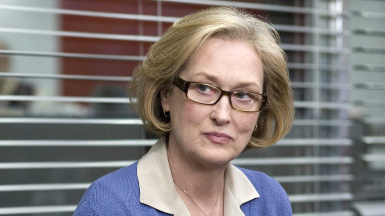 Meryl Streep smiling as Janine, sitting in an office in Lions for Lambs