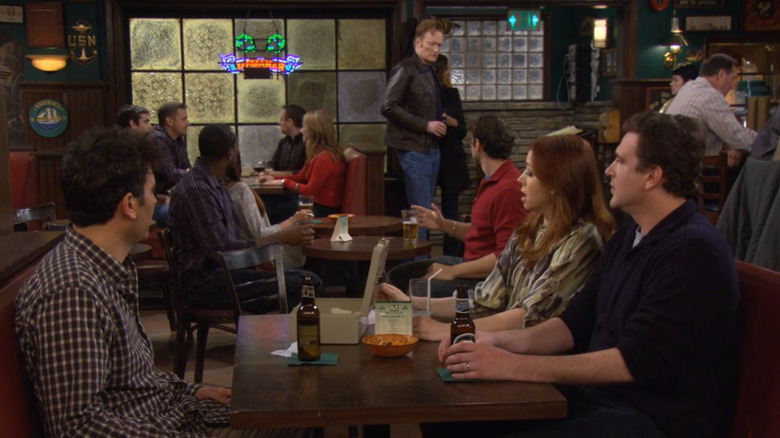Conan O' Brien in the background at MacLaren's Pub as Josh Radnor, Alyson Hannigan, and Jason Segel as Ted Mosby, Lily Aldrin, and Marshall Eriksen react to Barney's dramatic exit in How I Met Your Mother