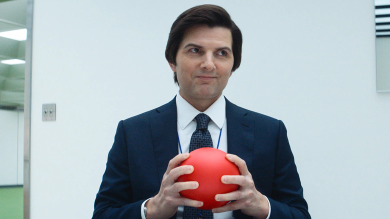 Mark S. grins while looking off to the right side and holding a bright red ball