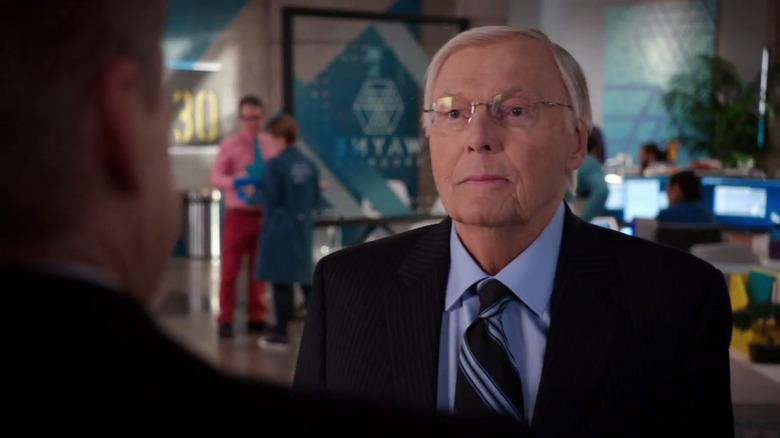 Adam West as Dean West speaking with someone in Powerless