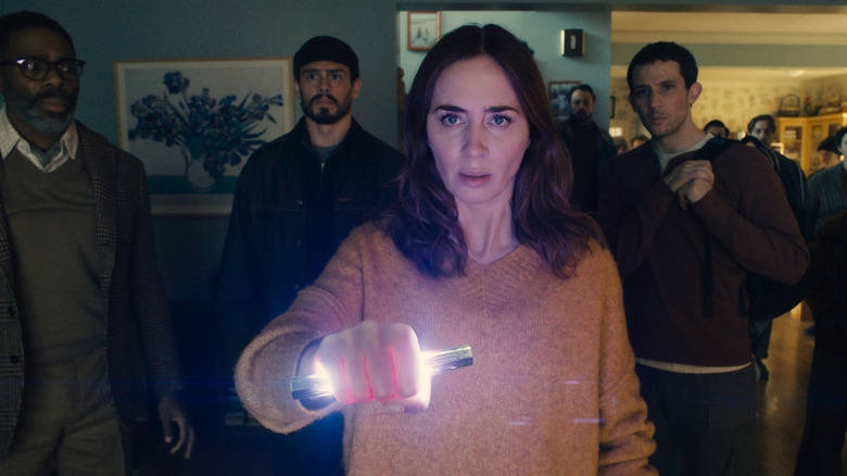 Emily Blunt as Margaret as she holds a strange glowing device in her hand in Disclosure Day