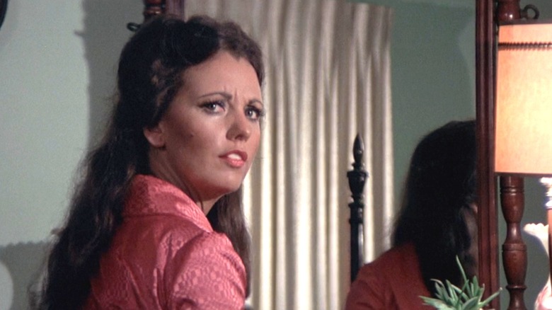 Dawn Wells' Helen Reed looks confused as she stands at a dresser in her home in The Town that Dreaded Sundown
