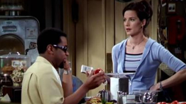 Jake at a counter opposite Reggie on Becker