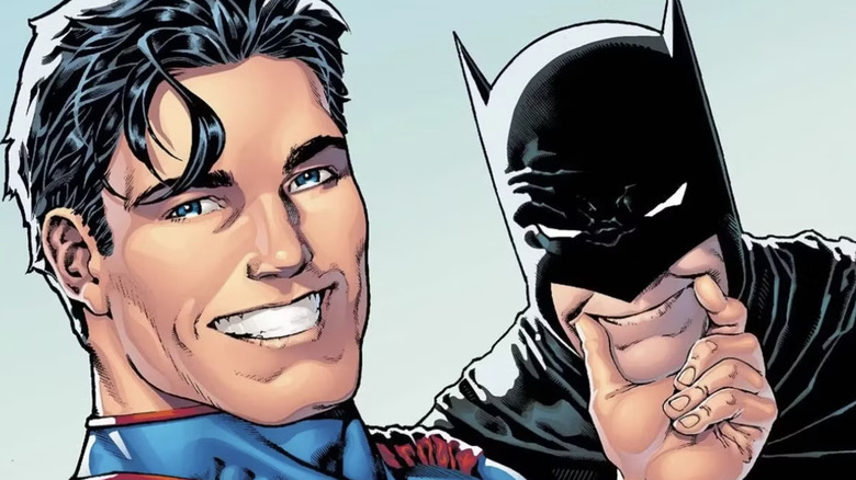 Superman holding Batman's face in a smile