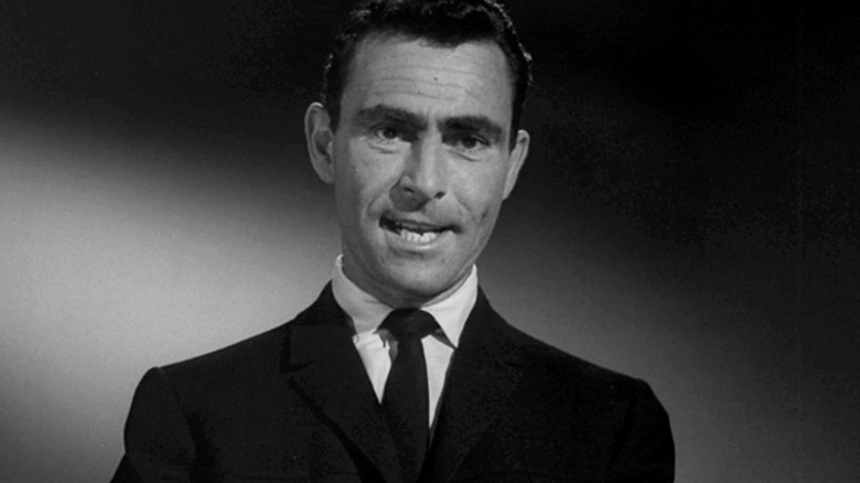 Rod Serling stands against a plain background in The Twilight Zone