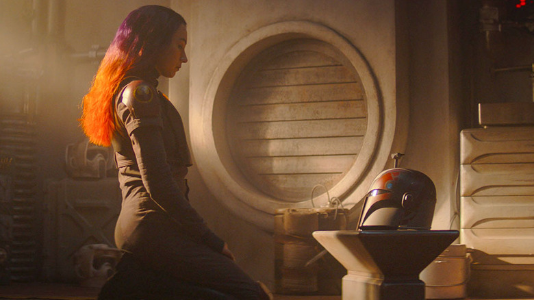 Ahsoka's Sabine Wren (Natasha Liu Bordizzo) kneeling before her Mandalorian helmet