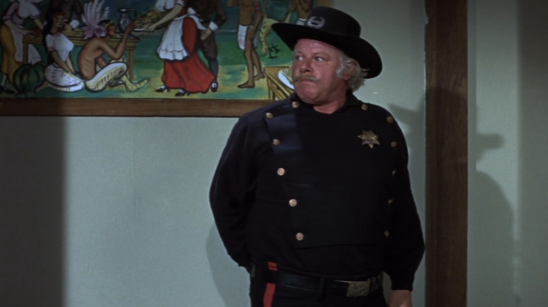 Alan Hale Jr's Tobaccy looks off to his right as he stands in a hallway in There was a Crooked Man