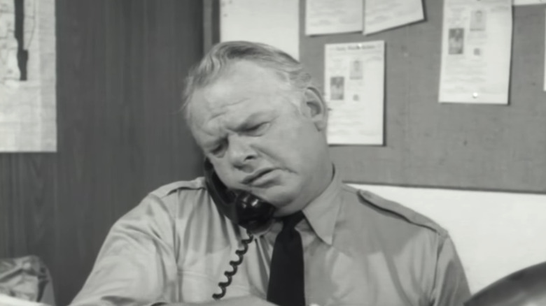 Alan Hale Jr.'s Sheriff Townsend speaks on the phone as he sits at his desk in The Crawling Hand