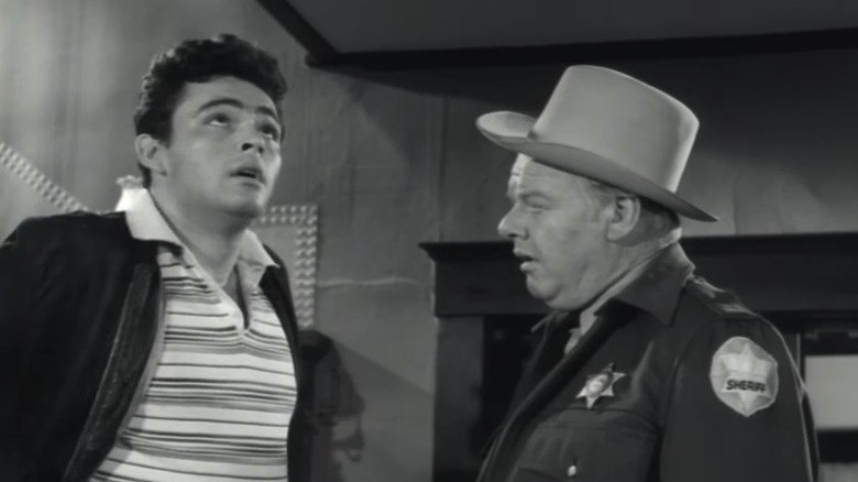 Rod Lauren's Paul Lawrence stands looking up next to Alan Hale Jr.'s Sheriff Townsend in The Crawling Hand