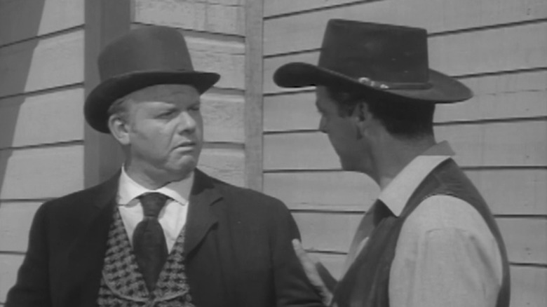 Alan Hale Jr.'s Sculley looks at Rory Calhoun's Bill Longley as they stand outside in The Texan