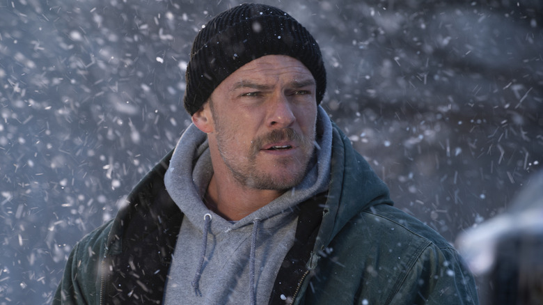 Alan Richson in the role of Ed Schmidt stands in the snow in the regular angels