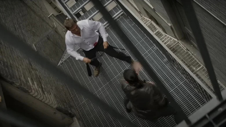 Alan Ritchson's Jack Reacher fights an enemy on a fire escape in Reacher