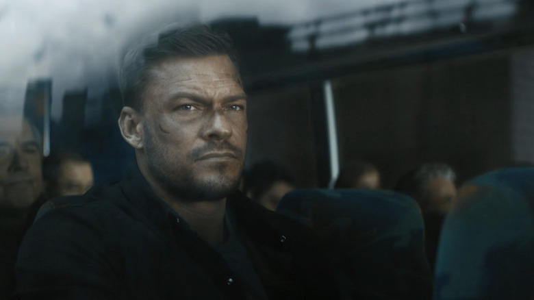 Alan Ritchson's Jack Reacher is seen through the window of a bus in Reacher