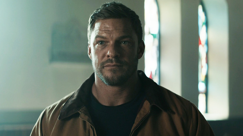 Alan Ritchson's Jack Reacher stands in a church in Reacher