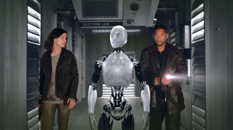Del, Susan, and Sony are walking in a corridor in me, robot