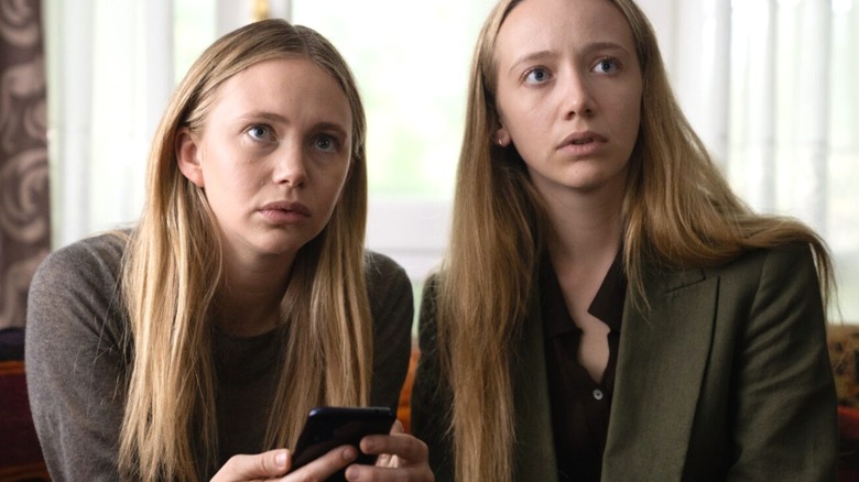 Twins Lily and Abby look serious while sitting together in Girl Taken