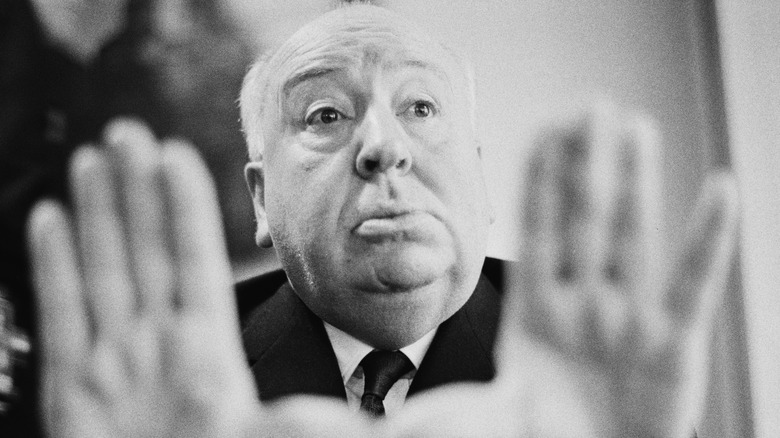 Alfred Hitchcock with his hands up 