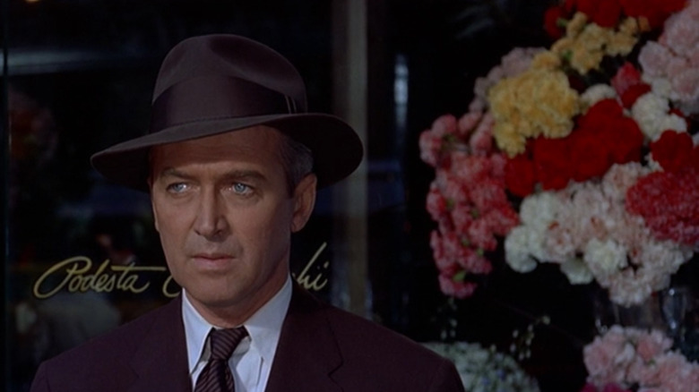 Jimmy Stewart exits flower shop wears fedora