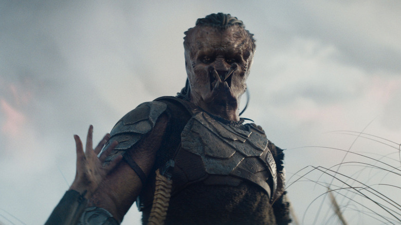 Dimitrius Schuster-Koloamatangi as Dek looking down at Thia in Predator: Badlands