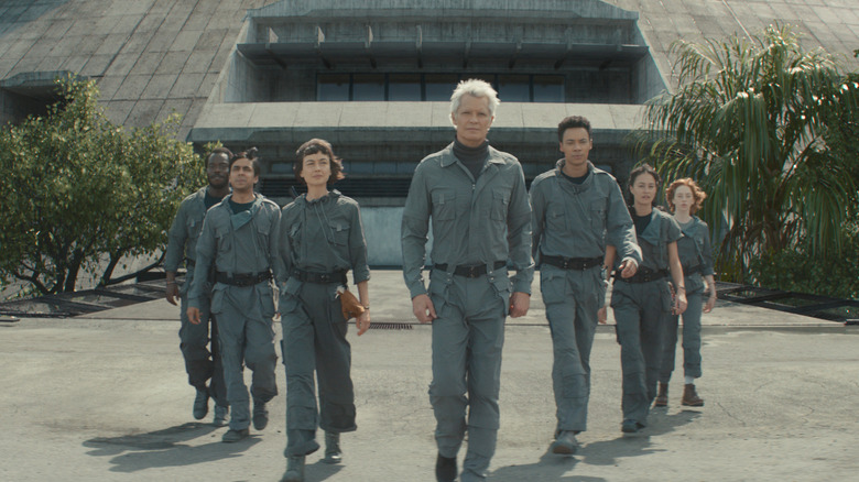 Jonathan Ajayi as Smee, Adarsh Gourav as Slightly, Sydney Chandler as Wendy, Timothy Olyphant as Kirsh, Kit Young as Tootles, Erana James as Curly, and Lily Newmark as Nibs walking outside in a tree-lined courtyard in Alien: Earth