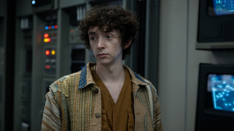 Boy Kavalier looking dejected wearing a raggedy coat at Neverland in Alien: Earth