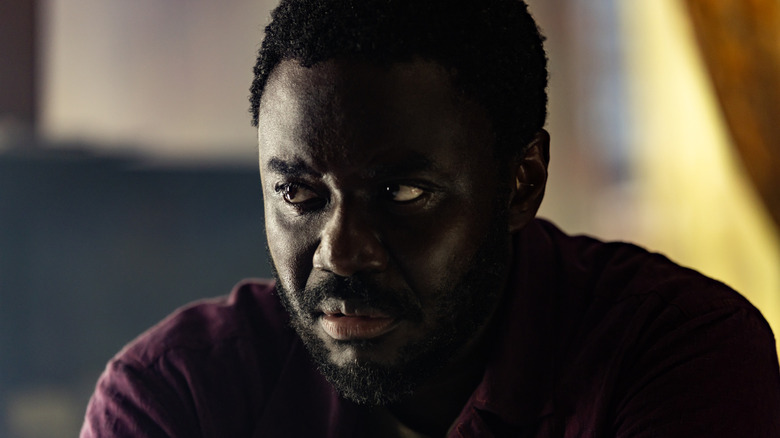 Morrow leaning forward intently in a red shirt in Alien: Earth