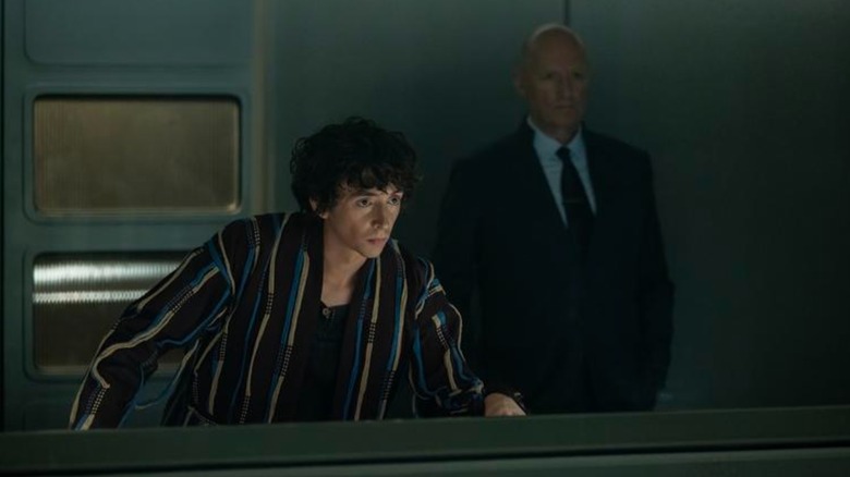 The boy of Samuel Plenekin Cavalier tends to monitor something while Adam Adam Adam Adam, Adam, stands in the background, in the foreigner: Earth