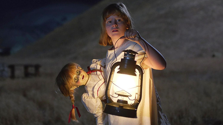 Linda holds both Annabelle the doll and a comically large lantern in Annabelle: Creation
