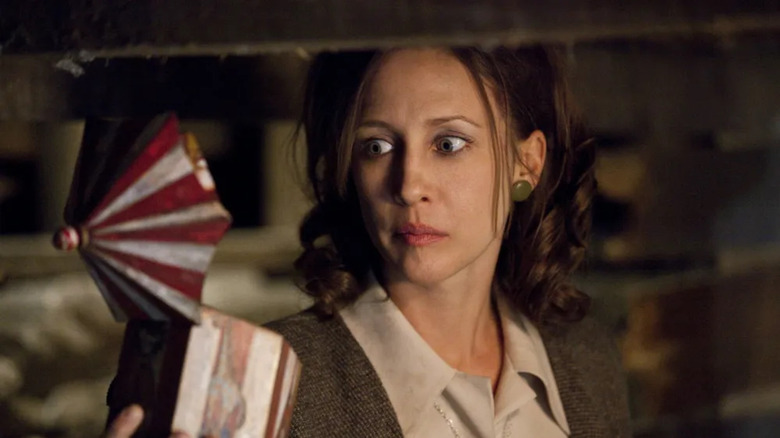 Lorraine Warren looks at a spooky music box with wide eyes in The Conjuring