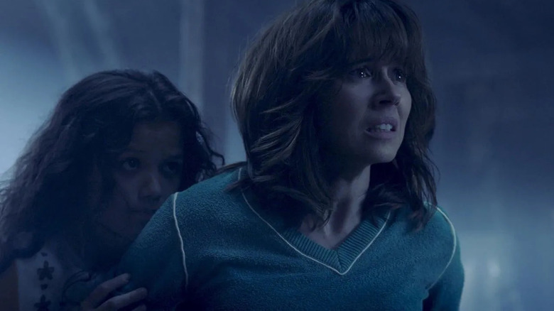 Anna Tate-Garcia looks afraid while her daughter Samantha cowers behind her in The Curse of La Llorona