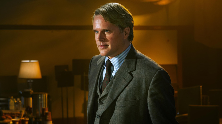 Cary Elwes as Dr. Lawrence Gordon standing in a jacket and tie in Saw 3D