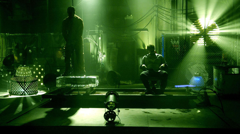 Donnie Wahlberg as Eric Matthews hung by the neck and standing on an ice block and Costas Mandylor as Mark Hoffman sitting down in a warehouse in Saw IV