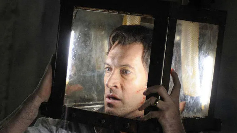 Scott Patterson as Peter Strahm looking frantic with his head stuck in a see-through box in Saw V