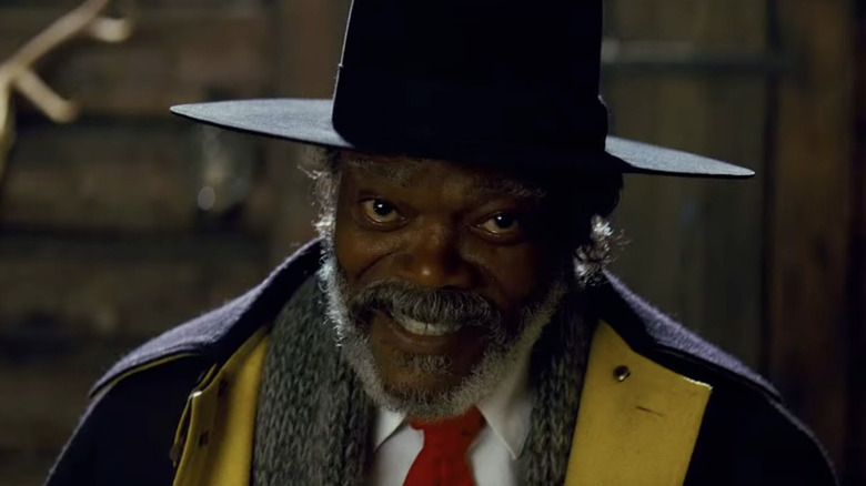 Samuel L. Jackson as Major Marquis Warren wearing a hat and scarf while in the barn in The Hateful Eight
